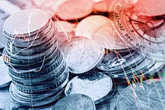 Pile and a stack of coins with technical chart of financial instruments.