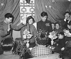1957年春节，沈阳风动工具厂的工人鞠复海（新郎）和俞凤仙（新娘）在婚礼仪式上接受朋友们的祝贺。（摄影：于肇） ​​​​