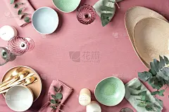 年夜饭上桌。前视图。副本的空间。粉红色破旧的背景上放着空空的餐盘、碗、蜡烛和桉树花。