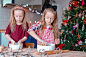 Adorable happy little girls baking Christmas gingerbread cookies in Xmas eve