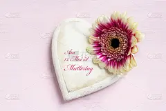 白色的木制心形和亮粉色的背景上的花的头，德语文本Alles Liebe zum Muttertag，