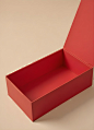 A-red-rectangular-box-with-a-lid-placed-on-a-beige