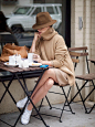 Street style in Paris - a beige sweater dress to white sneakers and a beige hat looks stylish and unexpected.: 