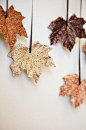 DIY: collect fallen leaves, melt candlewax into a pan and drop the leaves in. When both sides are covered, dip them in glitter and then hang them up by ribbons to dry.