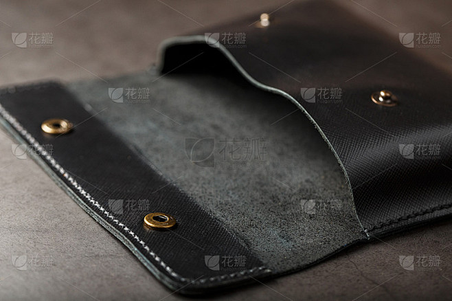 黑色皮夹，真皮，黑色背景。手工制作的皮革产品