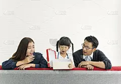 亚洲女儿在客厅的沙发上和爸爸妈妈一起打开礼物。概念的家人的生日。