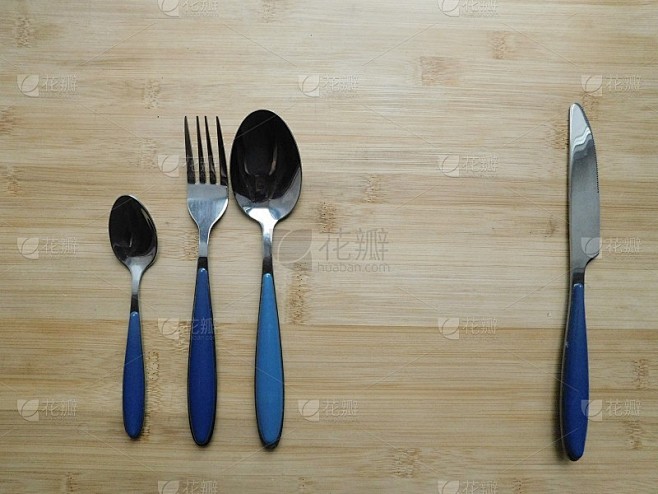 餐具:叉子，勺子和刀放在质朴的木桌上。