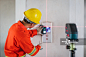 亚洲建筑工程师在工地用电梯旁的激光矫直机测量墙面图片素材