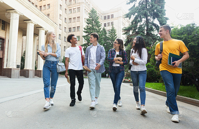 快乐的学生们在大学大楼外散步