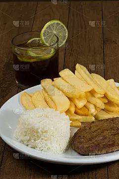 美味的汉堡配米饭和薯条。一杯清爽的柠檬可乐汽水。垂直照片与文字空间。