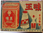 an old tin sign with chinese writing on it and a bottle of liquor in the background