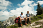 Mature couple sitting on grass, hiking in mountains, Tannheim Valley, Austria
