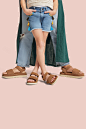 Close up of a kid's and and adult's legs, standing together and wearing UGG sandals.