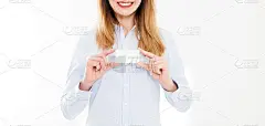 年轻女子在衬衫中拿着名片孤立在一个白色的背景，女性的手拿着名片。经营理念。本空间