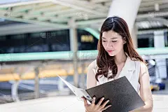 具有建筑和城市背景，在办公室外工作和运营的亚洲商业女性。