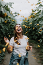 woman standing between sunflowers during daytime