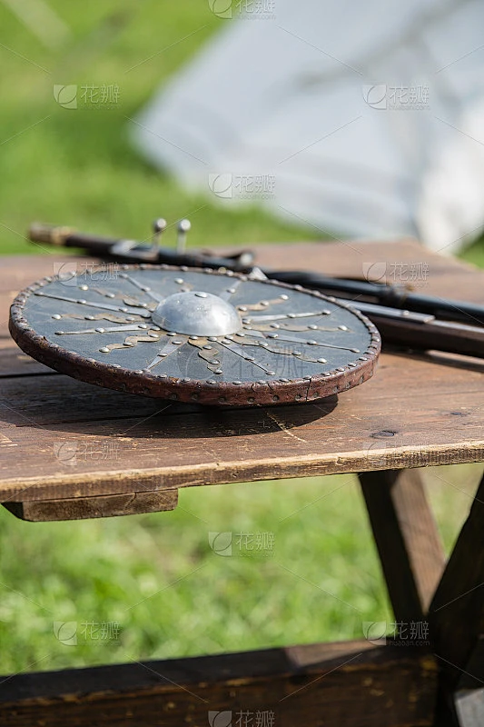 木桌上的圆形和金属盾牌:中世纪金属盔甲和武器素材-花瓣网