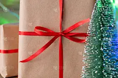 用再生纸包装的圣诞礼品盒和红色丝带蝴蝶结