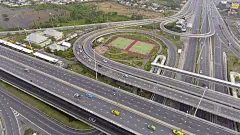 在泰国曼谷，绕着堆叠的高速公路飞行，有交通和圆圈，鸟瞰