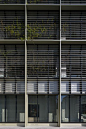 the side of an office building with windows covered in blinds
