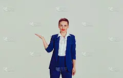 看这里。女商人展示的复印空间孤立的浅绿色白色的办公室墙壁背景。短发，红唇，蓝西装，白衬衫正装