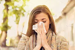 有过敏症状的女人在擤鼻涕