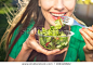 Portrait of attractive caucasian smiling woman eating salad, focus on hand and fork. soft, backlight
