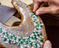 craftsman setting the stones of a emerald and white diamond necklace