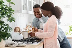 夫妇的家庭生活。幸福的黑人夫妻一起在厨房做饭