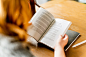 Photo by Melanie Deziel on Unsplash : Woman reading a book at a cafe, with a notebook, pen and earbuds nearby. . Download this photo by Melanie Deziel on Unsplash