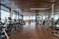 Free Interior of modern spacious fitness club with various sports machines and equipment placed on parquet floor near panoramic windows Stock Photo