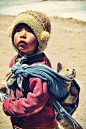 Human spirit. Bolivian child with cat in baby sling . Despite extreme poverty in areas the children and people of Bolivia live joyfully.: 