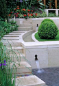 Contemporary style water feature with steps, rill and retaining wall.