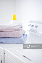 Folded towels and detergent on white washer and dryer