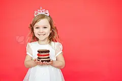 Blond hair little girl holding cake on red background