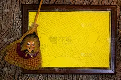 万圣节。木框带网，黄色纸空白带文字
扫帚上的女巫玩具。记录列表。本空间