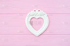 石膏复古相框的形状的心在粉红色的木制背景与地方的文字。完美的贺卡，邀请，情人节，婚礼
