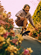 Fifty year old Chinese mother playing skateboarding,smiled, surrounded by flowers, art by Rinko kawauchi, in the style of naturalistic poses, low angle, youthful energy, body extentions, analog film, super detail, dreamy lofi photography, colourful, volum