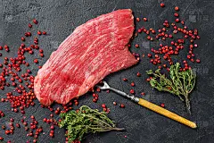 生牛腩牛排配迷迭香和粉盐。新鲜大理石牛肉黑安格斯。黑色背景。俯视图