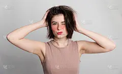 该去美容院了。随意女人的表情，她不去温泉，发廊或美容院很长一段时间。超过灰色背景复制空间。