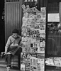 1947年，上海。认真读报的书报摊小贩，他穿着牛仔裤和新式皮鞋