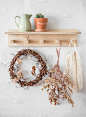 秋天的静物-木制的架子上有藤花环，陶瓷壶，仙人掌，干花，布袋在一个明亮的房间。舒适环保家居风格