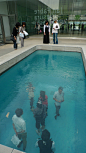 Leandro Erlich...http://www.abenazzouz.fr/?p=1206 *Translated from French: Magnificent game on the direction.  Exterior one, it is astonishing to see the people in the swimming pool.  Interior, see the spectators to the outlines render fuzzy by the waves 