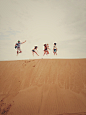 people jumping on sand