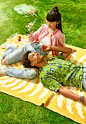 This may contain: two women laying on a blanket in the grass