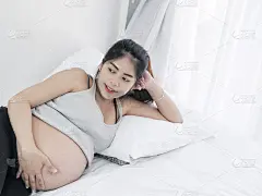 亚洲孕妇在家卧床休息，生活理念。