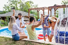 一群朋友在暑假享受在泳池边的派对。