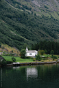 传统的白漆木结构教堂，在挪威峡湾深处。Traditional white painted timber church deep in the Norwegian Fjords.by agencia