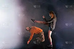 一对舞蹈情侣展示了他们的动作:小女孩将腿高高抛向天空，而小男孩则向后倾向地面。