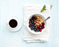 Healthy breakfast set. Bowl of oat porridge with fresh berries, almond and honey over white napkin, 